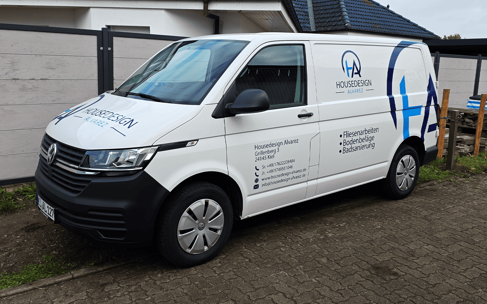 Weißer VW Transporter mit blauer Beschriftung Housedesign Alvarez