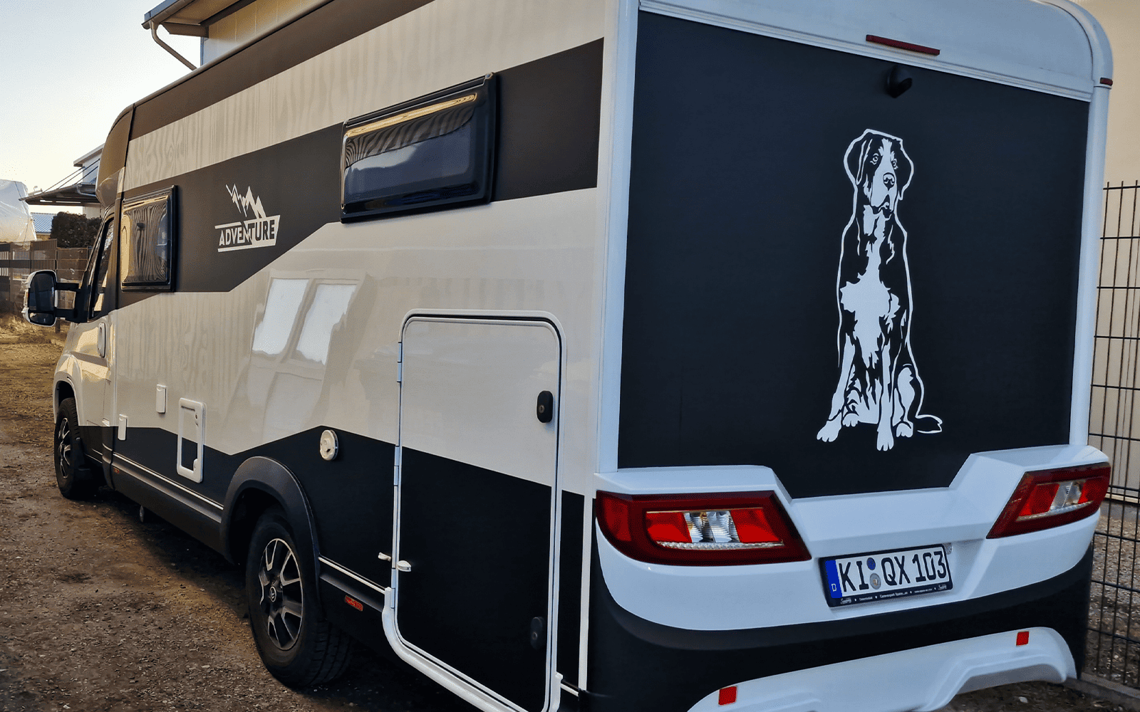 Heck des Wohnmobils mit schwarz-weißer Folierung und großer Hunde-Grafik
