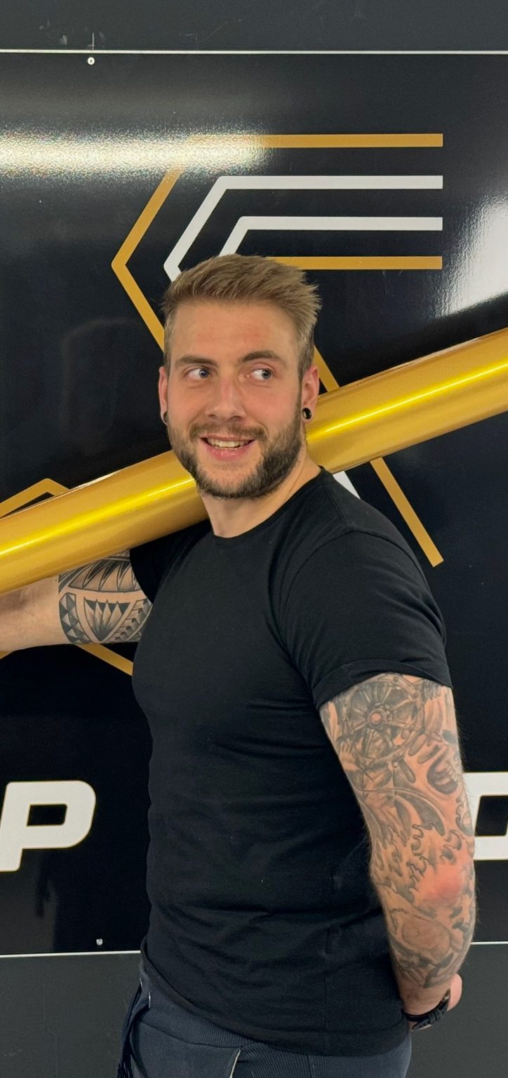 Joey Zornsch, Inhaber von Wrap Shed Folientechnik, mit einer Folienrolle in der Werkstatt in Stein bei Kiel