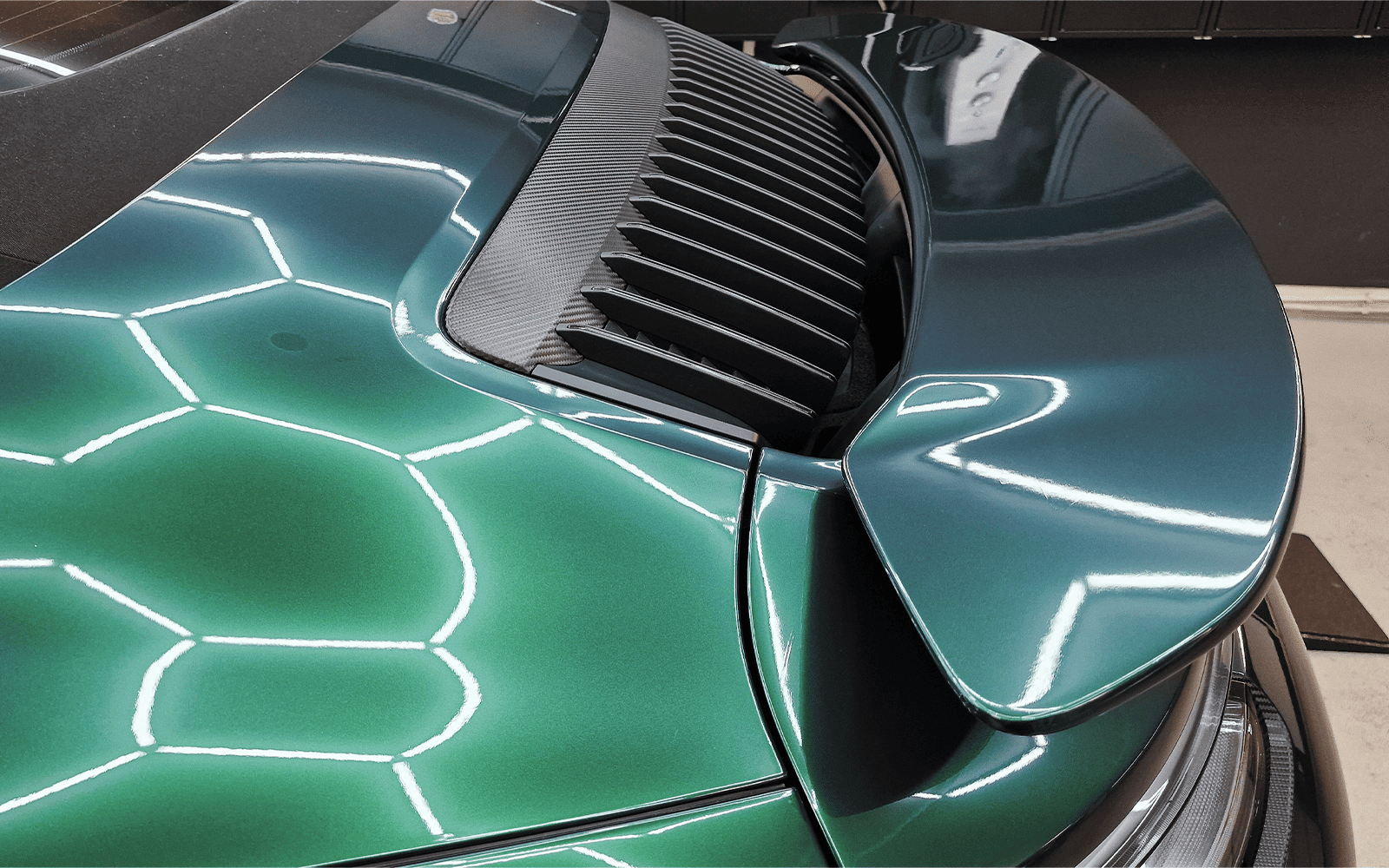 Heck des dunkelgrün folierten Porsche 911 Cabrios mit ausgefahrenem Spoiler