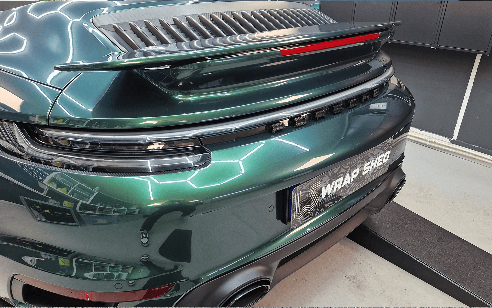 Detail des Heckspoilers am dunkelgrün folierten Porsche 911